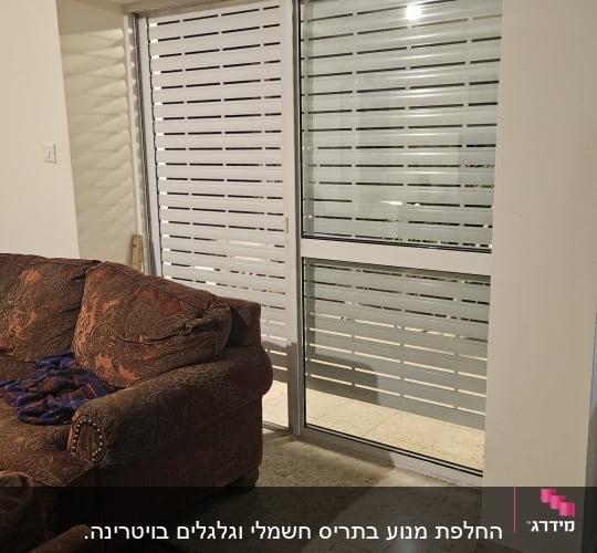 תריסים לבנים סגורים על חלון זכוכית גדול